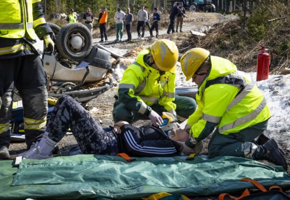 Kaksi pelastajaa hoitaa harjoituspotilasta.